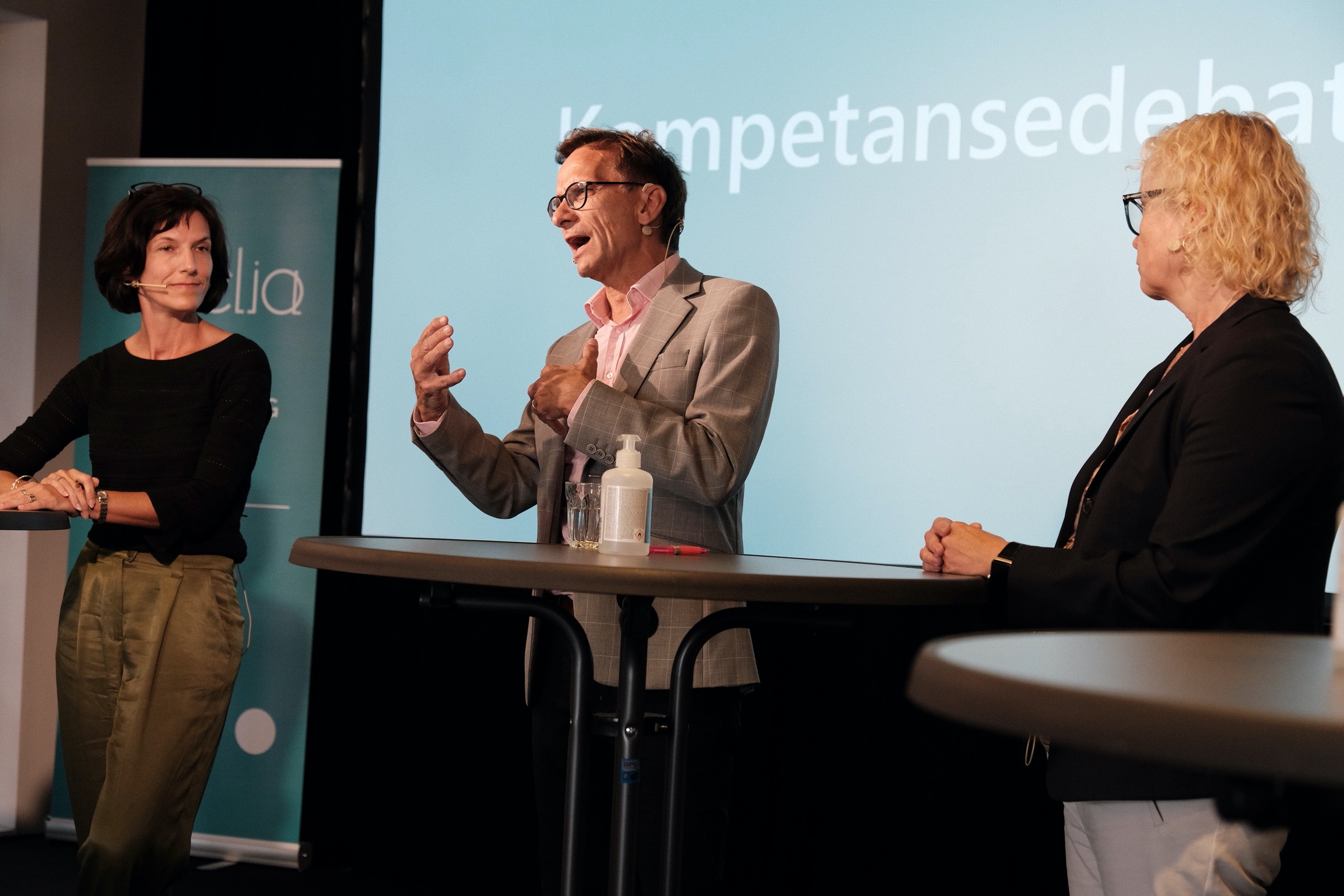 Bilde av to kvinner og en mann i et debattpanel.