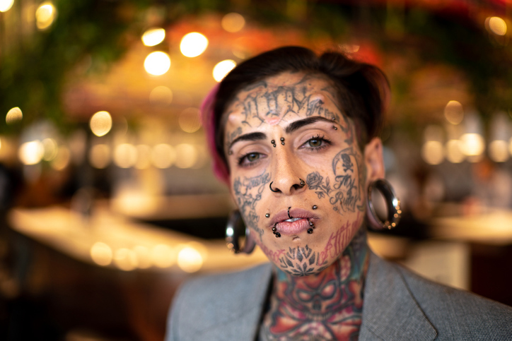 Kvinne med piercing og tatovering i ansiktet