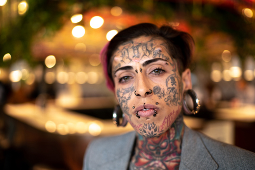 Kvinne med piercing og tatovering i ansiktet