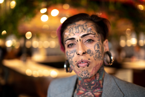Kvinne med piercing og tatovering i ansiktet