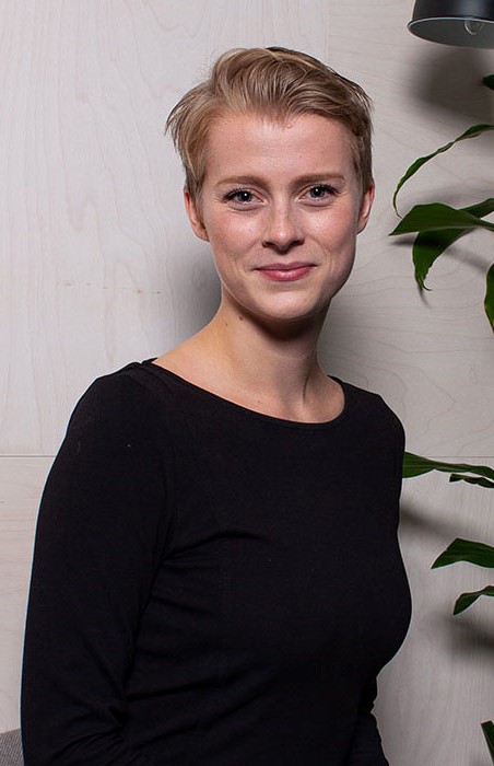 Kjersti som sitter ved en plante.