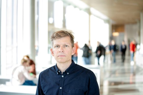 Torfinn Harding står i en lys gang.