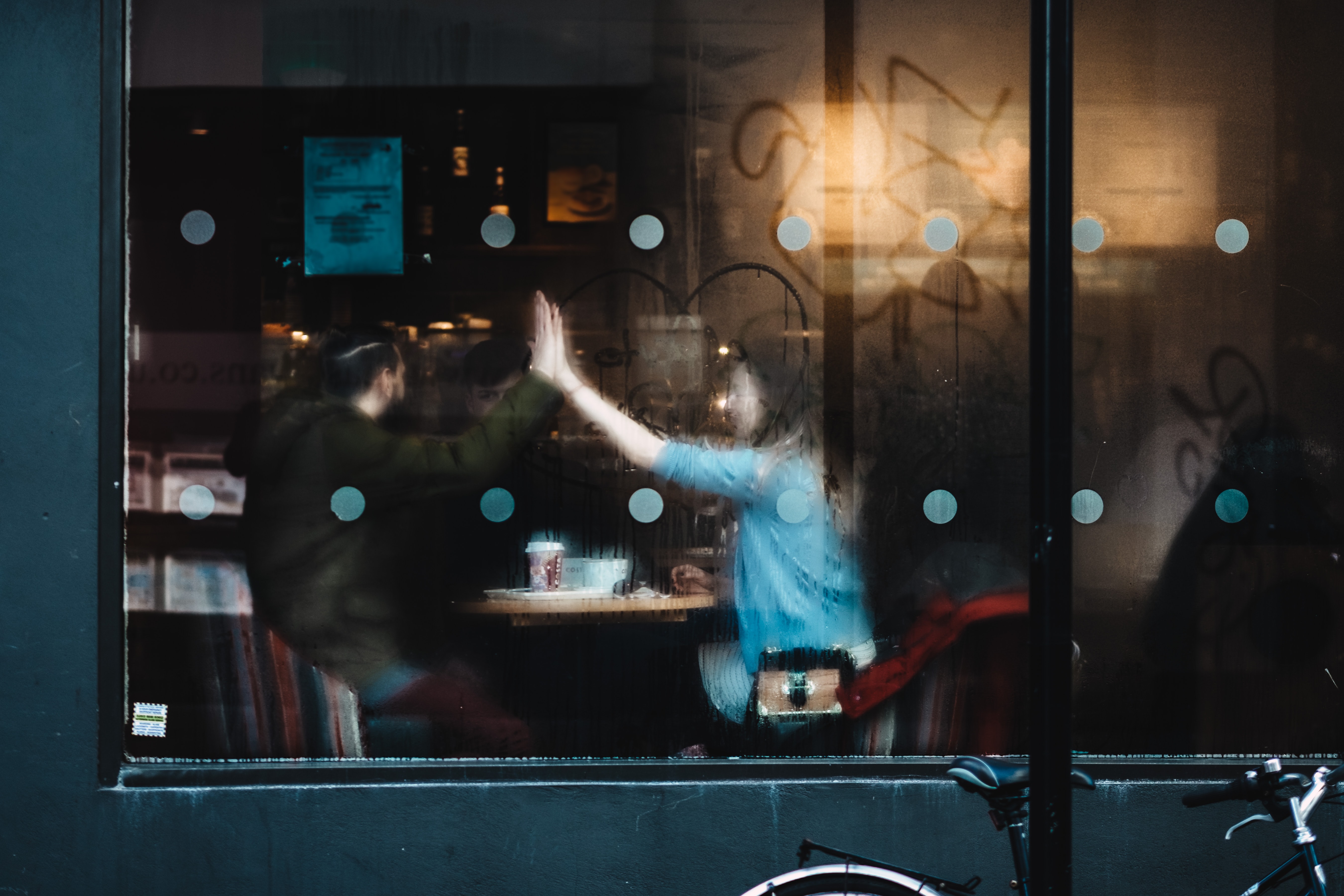 En mann og kvinne på kafe sett gjennom et vindu