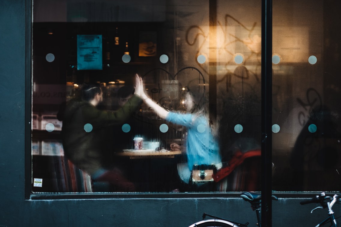 En mann og kvinne på kafe sett gjennom et vindu