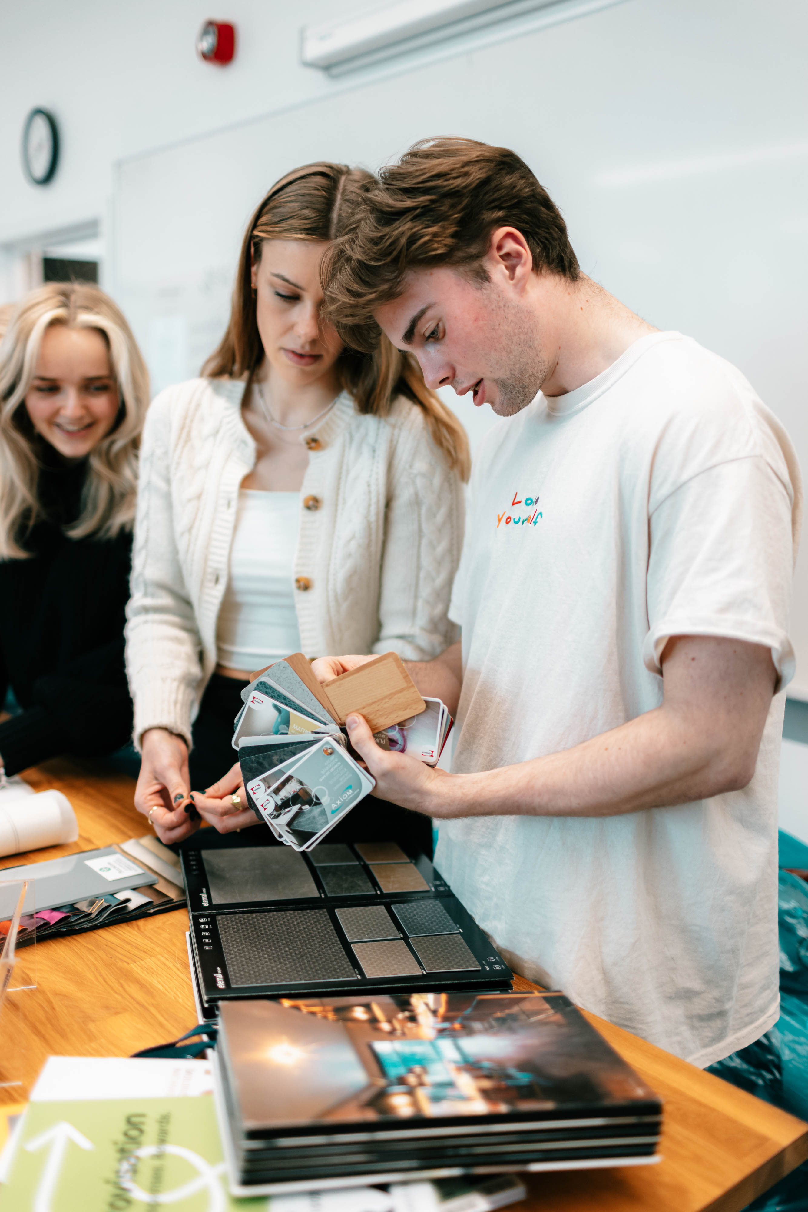 Tre studenter diskuterer materialer.