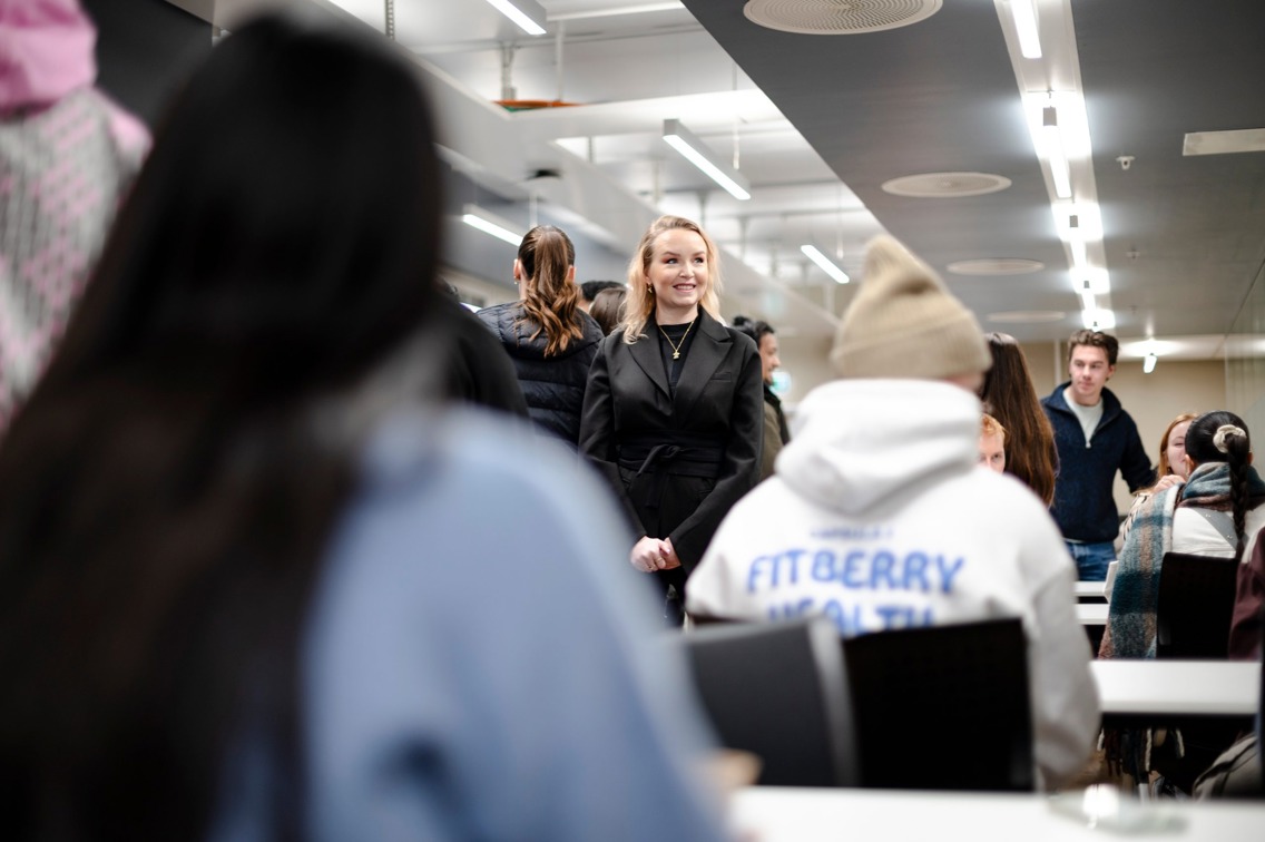Nesseth går gjennom et klasserom med studenter.