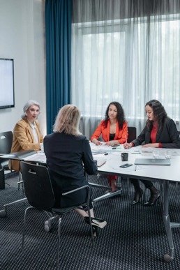 Fire kvinner som sitter i et jobbmøte og diskuterer