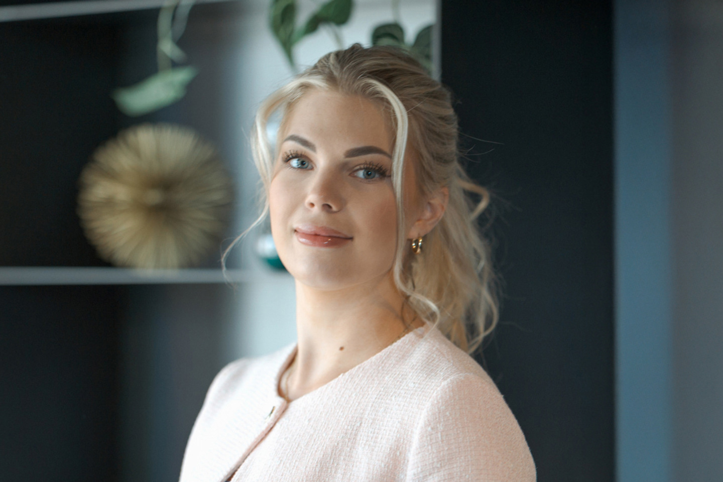 Portrett av Celine som ser inn i kamera, med sorte hyller i bakgrunnen.