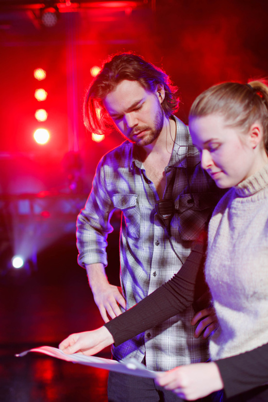 Studenter står på en scene og ser på en plan.