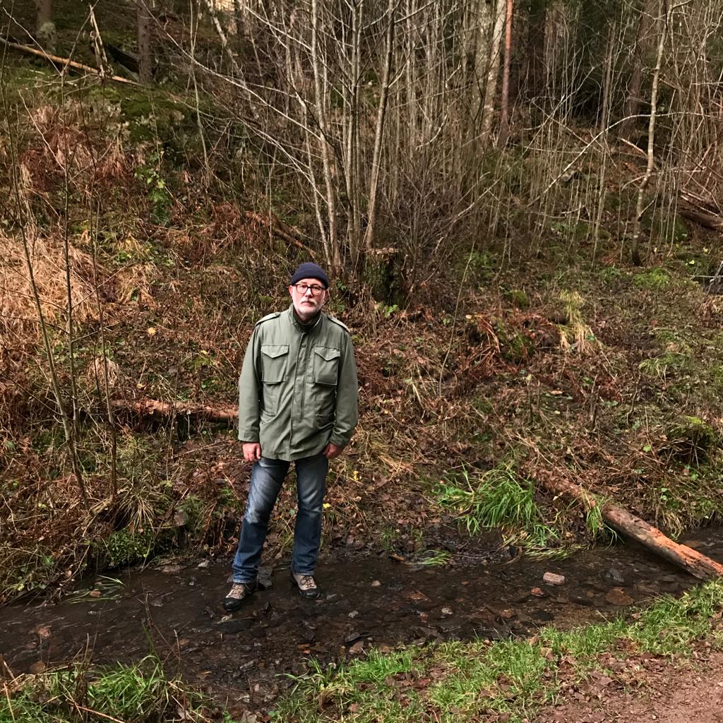 Chris Harrison ser på kamera mens han er fotografert utendørs i skogen