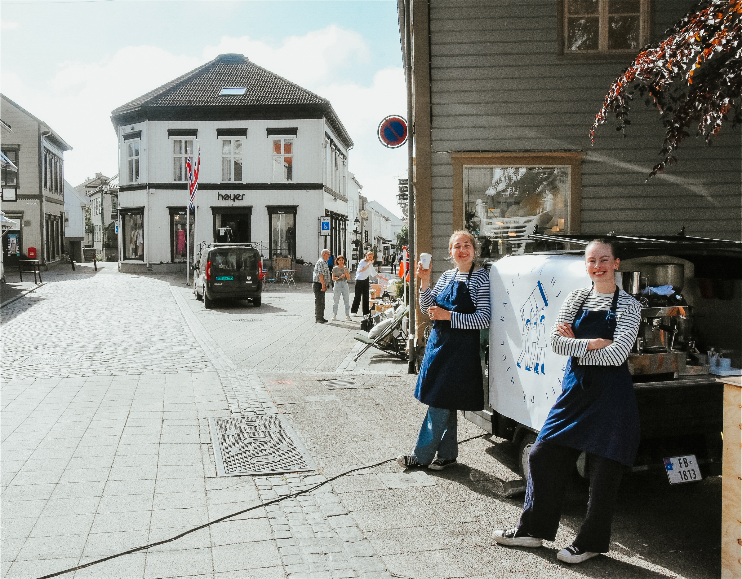 Hannah og Andrea poserer foran kaffebilen sin i gågata i Grimstad