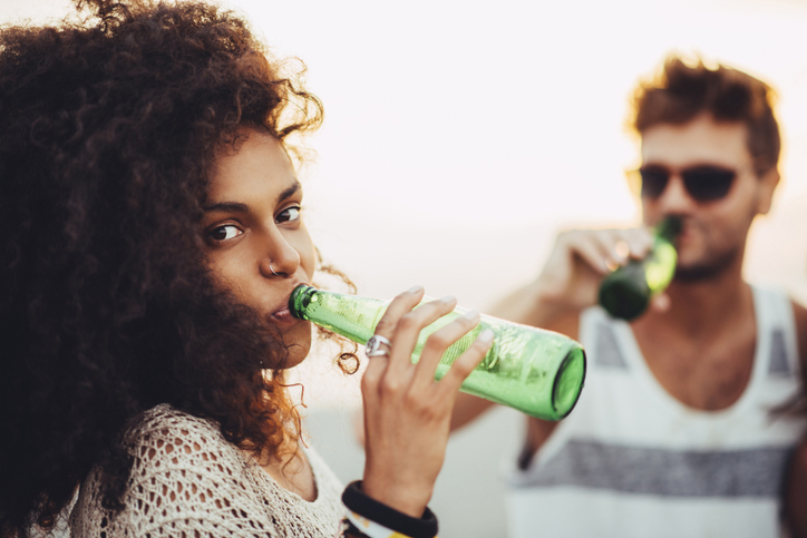 Woman and man drinking from bottles