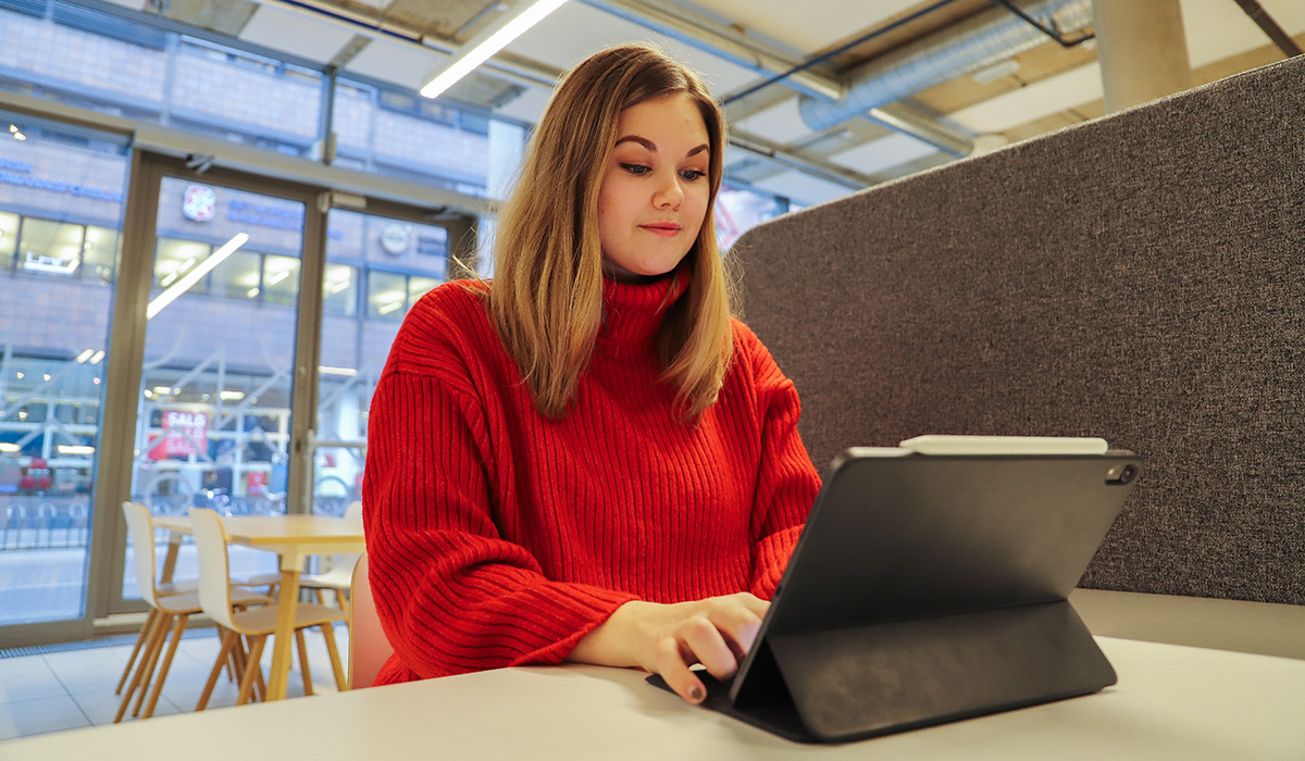 Emilie Evjen Berg som studerer Prosjektledelse på Fagskolen Kristiania, sitter på Campus Spikersuppa og jobber.