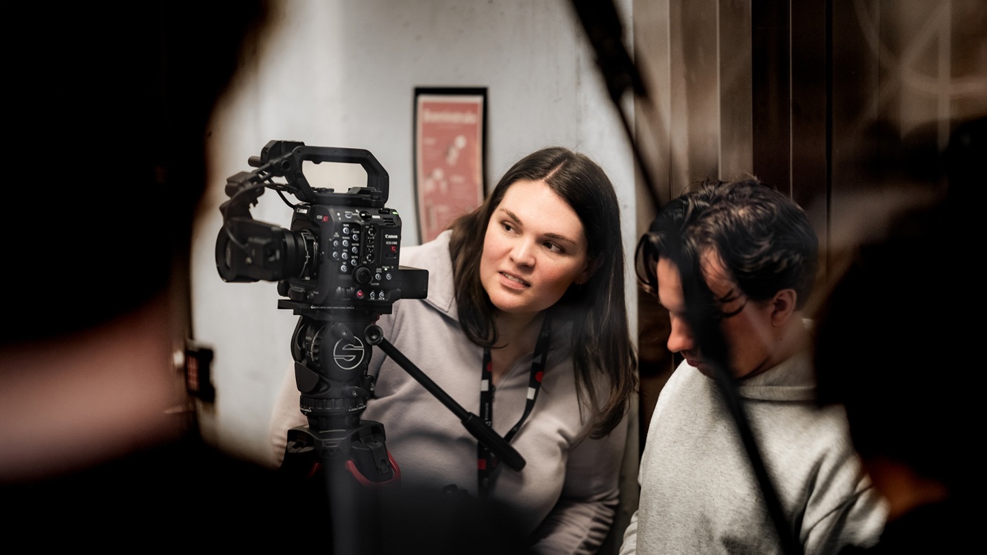 To personer samarbeider om å filme med et profesjonelt videokamera