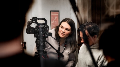 To personer samarbeider om å filme med et profesjonelt videokamera