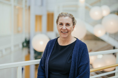 Dame med sort topp og mørkblå cardigan.