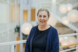 Dame med sort topp og mørkblå cardigan.