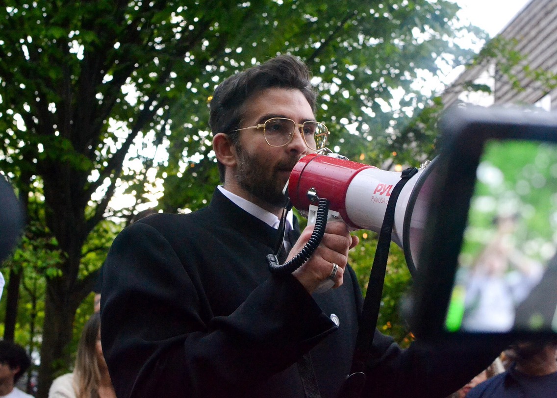 Hasan Piker snakker i en megafon under en demonstrasjon