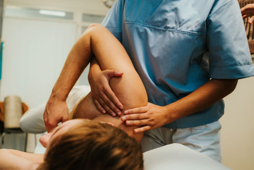 En osteopatstudent behandler en pasient for skuldersmerter