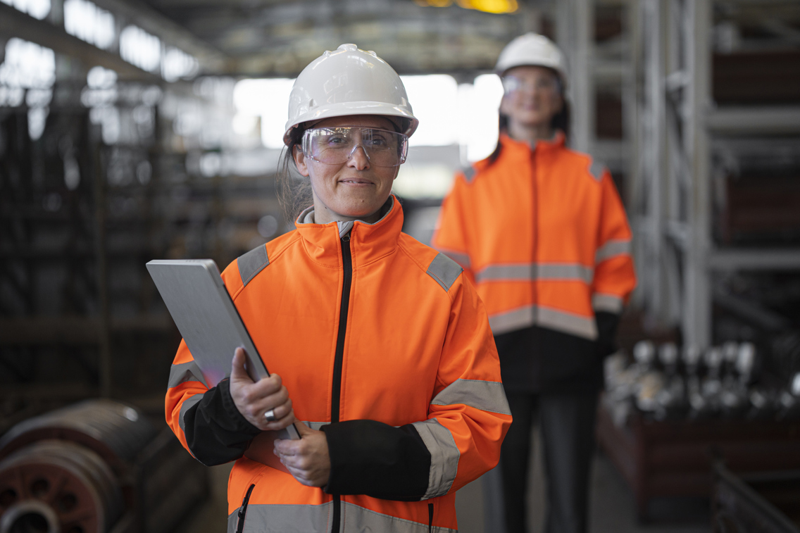 En kvinnelig ingeniør med uniform på arbeidsplassen med en blokk i hånda