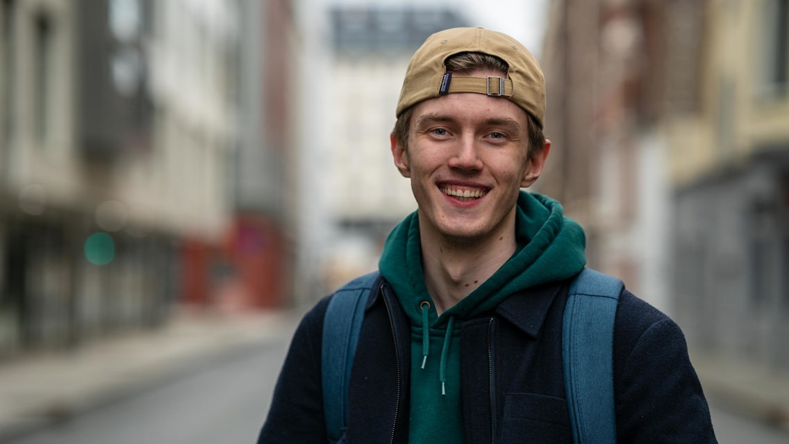 Foto av en mann i gaten utenfor Fagskolen Kristiania i Bergen.
