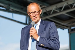 Friedrich Merz holder en mikrofon på en scene