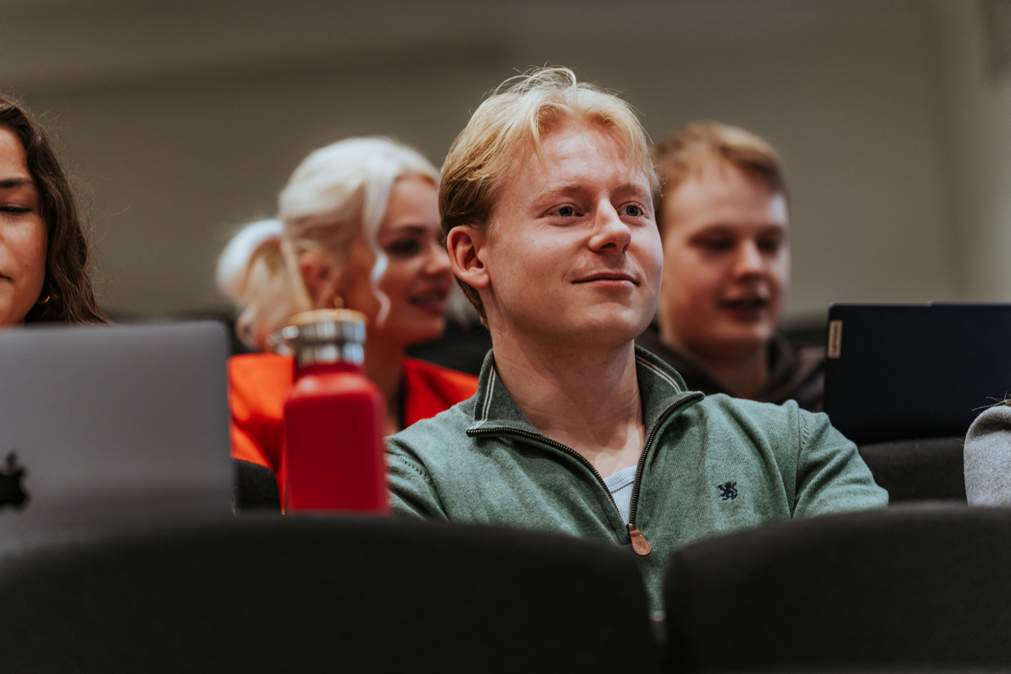 Fire studenter i forelesningssal.