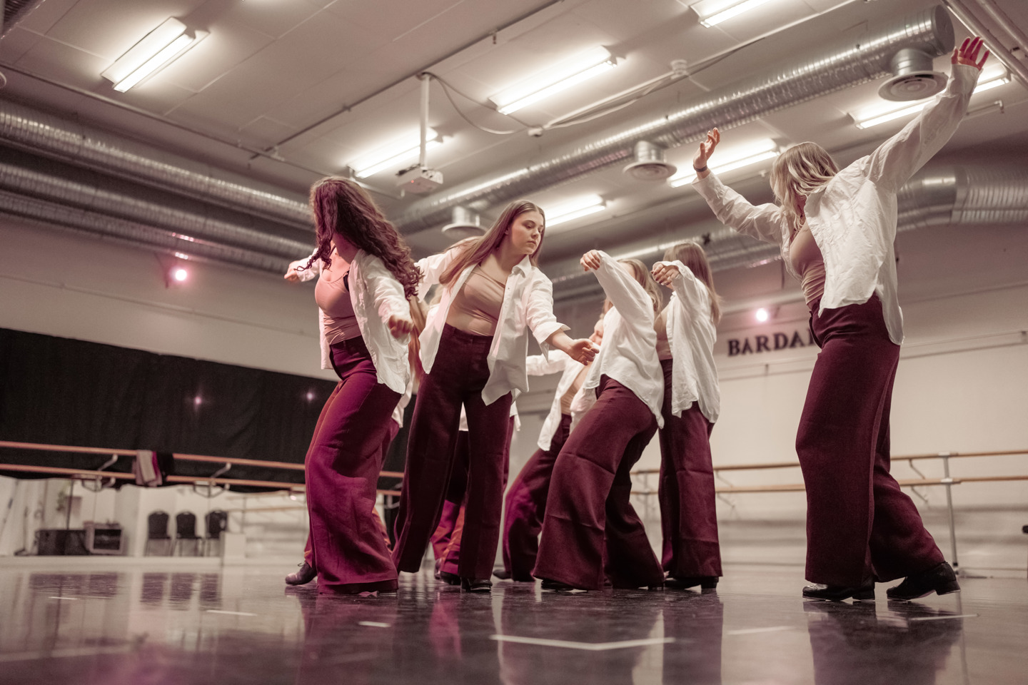 Fem studenter i dansetrening i moderne danse- og øvingssal