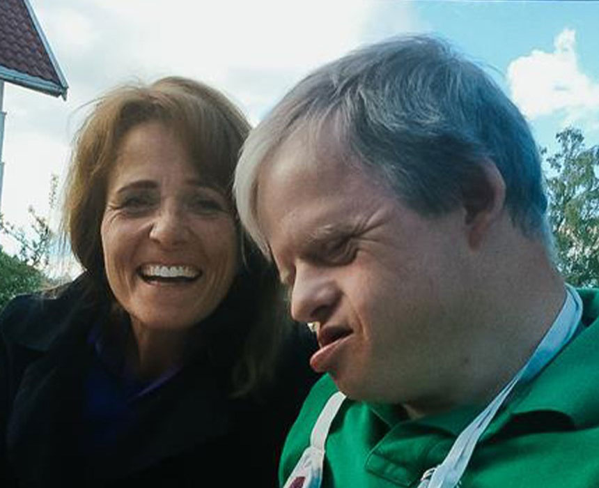 Foto av voksen kvinne sammen med sin sønn som har Downs syndrom.
