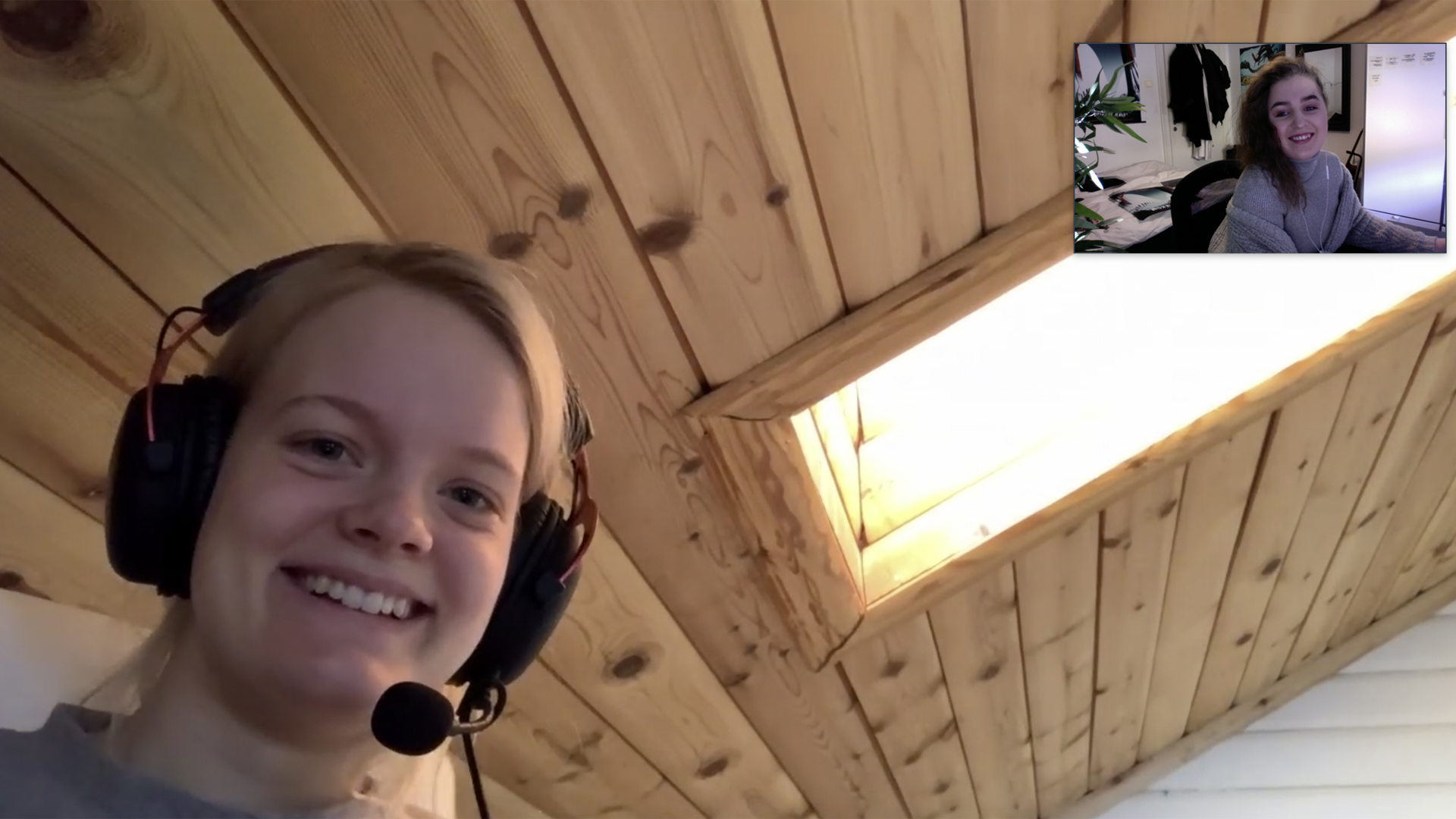Skjermbilde av Zoom-møte mellom studentene Frida og Guro fra hvert sitt hjemmekontor. Begge smiler.