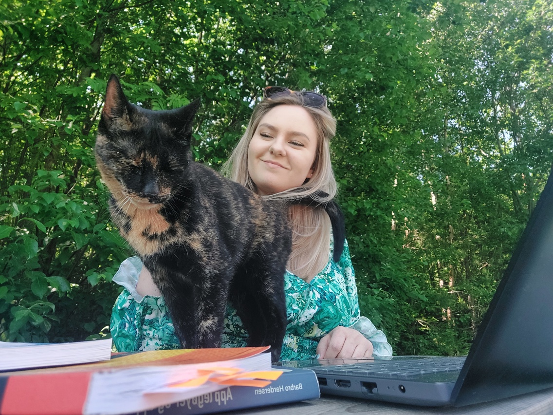 Tilfreds student med hund ved pc