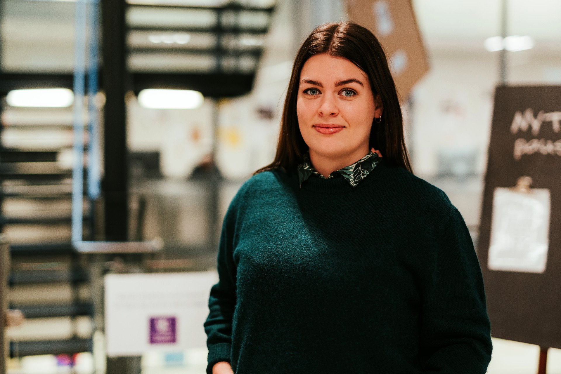 Frida står ved en trapp på campus i Oslo.