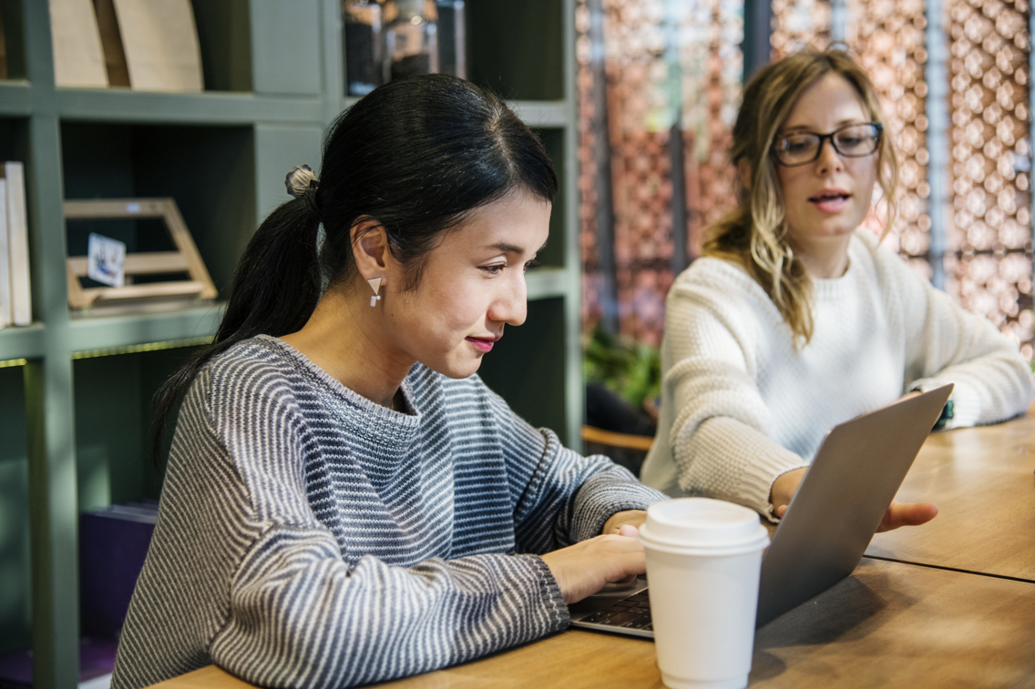 Two women at desk with laptop