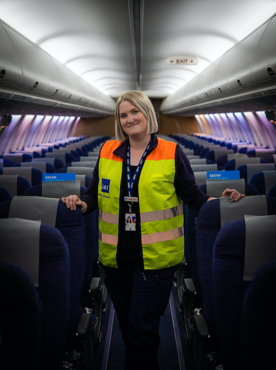 Foto av nettstudenten Mari Vesela på jobb for SAS. På bildet står hun innen i kabinen på et av SAS sine fly.