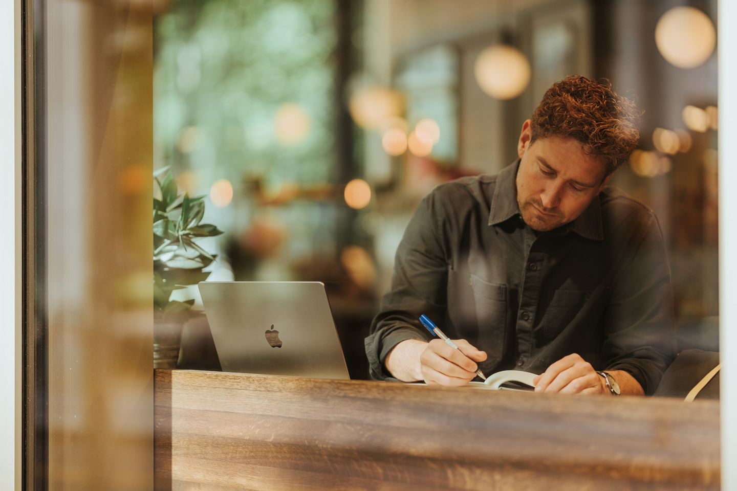 Nettstudent jobber med bok og PC.