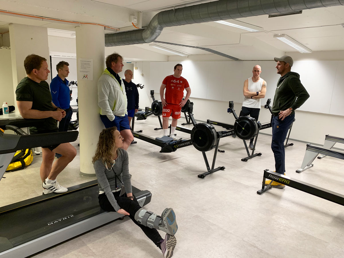 De ansatte ved høyskolen står i en ring rundt Olaf Tufte før han starter treningsøkta.