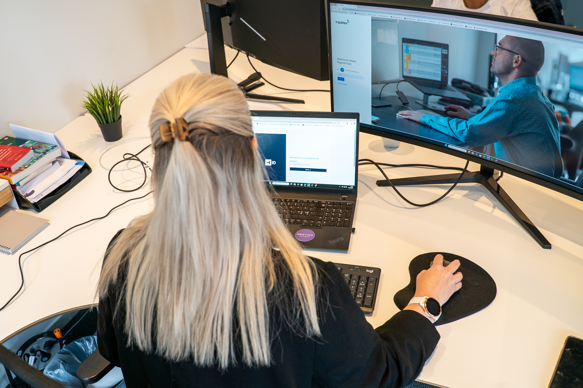 Bakhodet til Ragnhild som sitter ved pulten sin å jobber på datamaskinen.