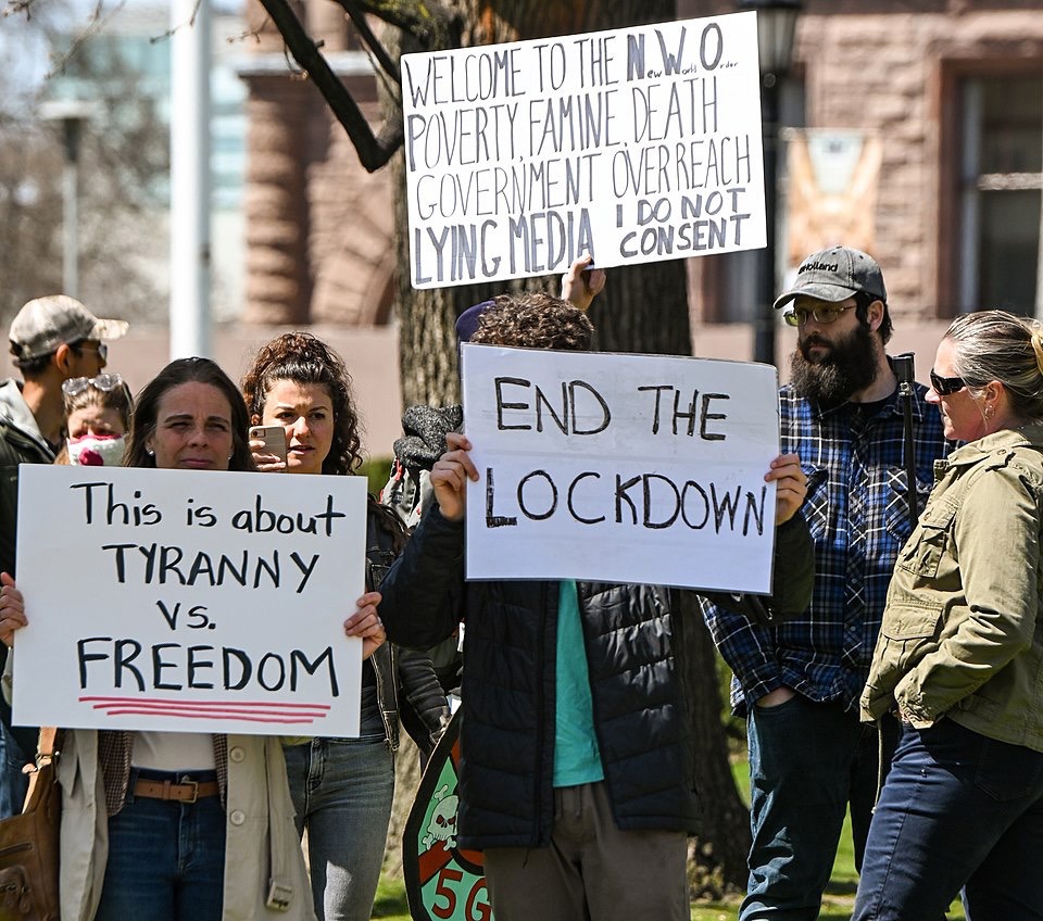 Demonstranter med plakater som "end the lockdown" og "this is about tyranny vs. freedom"