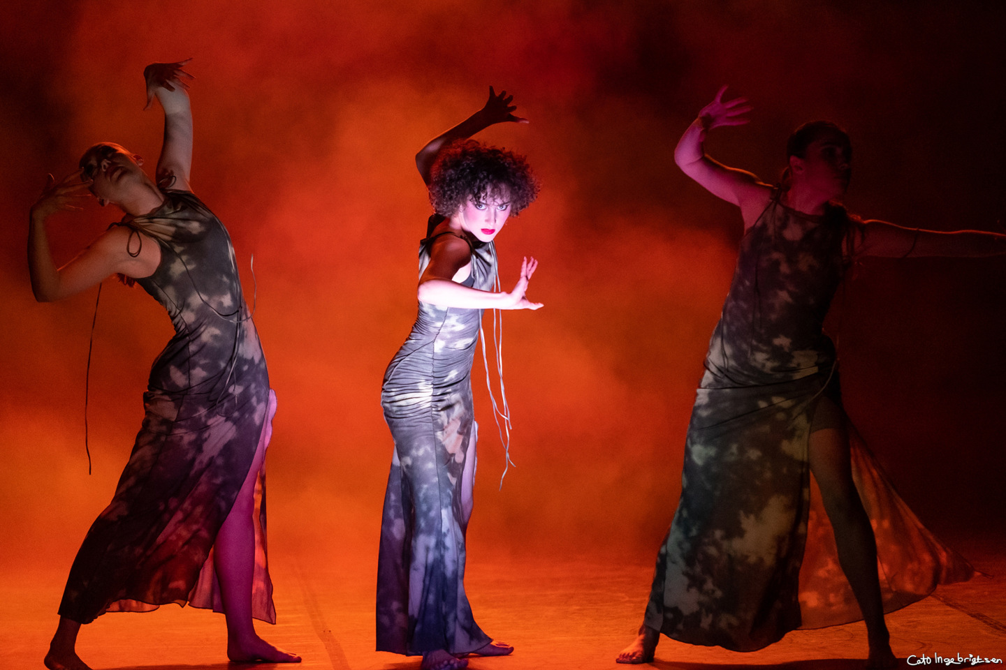 Tre dansere i dramatisk positur omgitt av røyk.