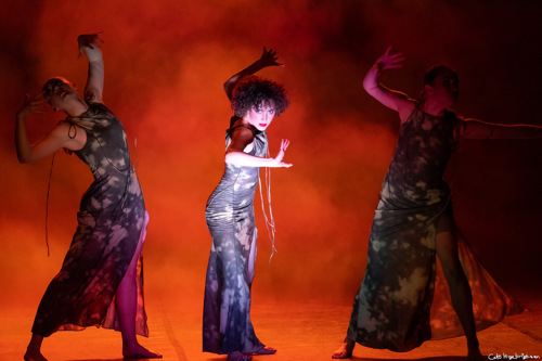 Tre dansere i dramatisk positur omgitt av røyk.