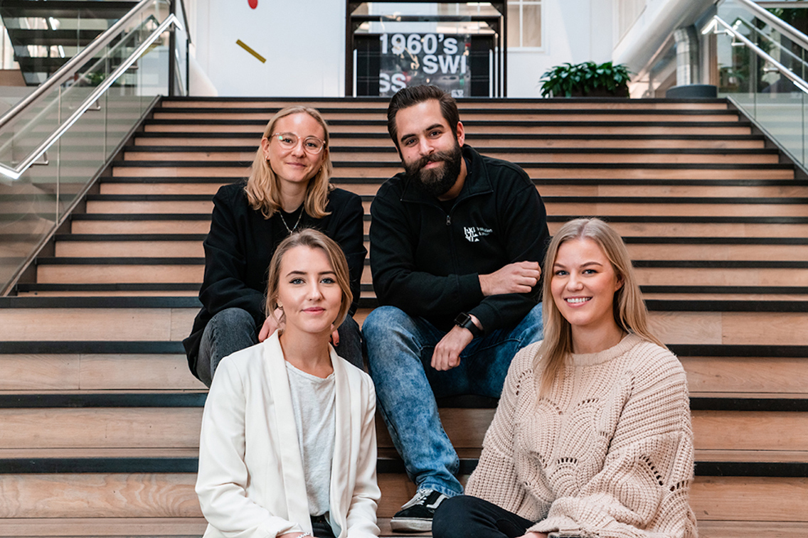 Studieveileder Dennis Haffner sitter på en trapp med 3 kvinnelige studenter.