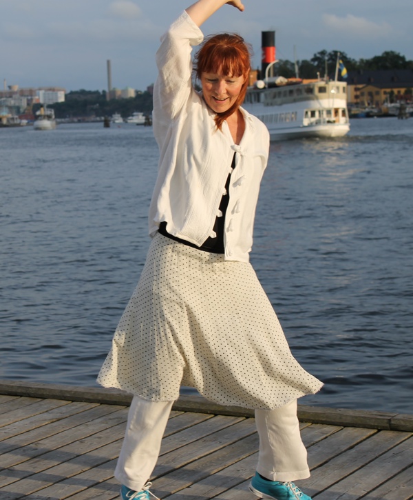 Hilde Rustad danser på en brygge i Stockholm, sjø og båt i bakgrunnen.