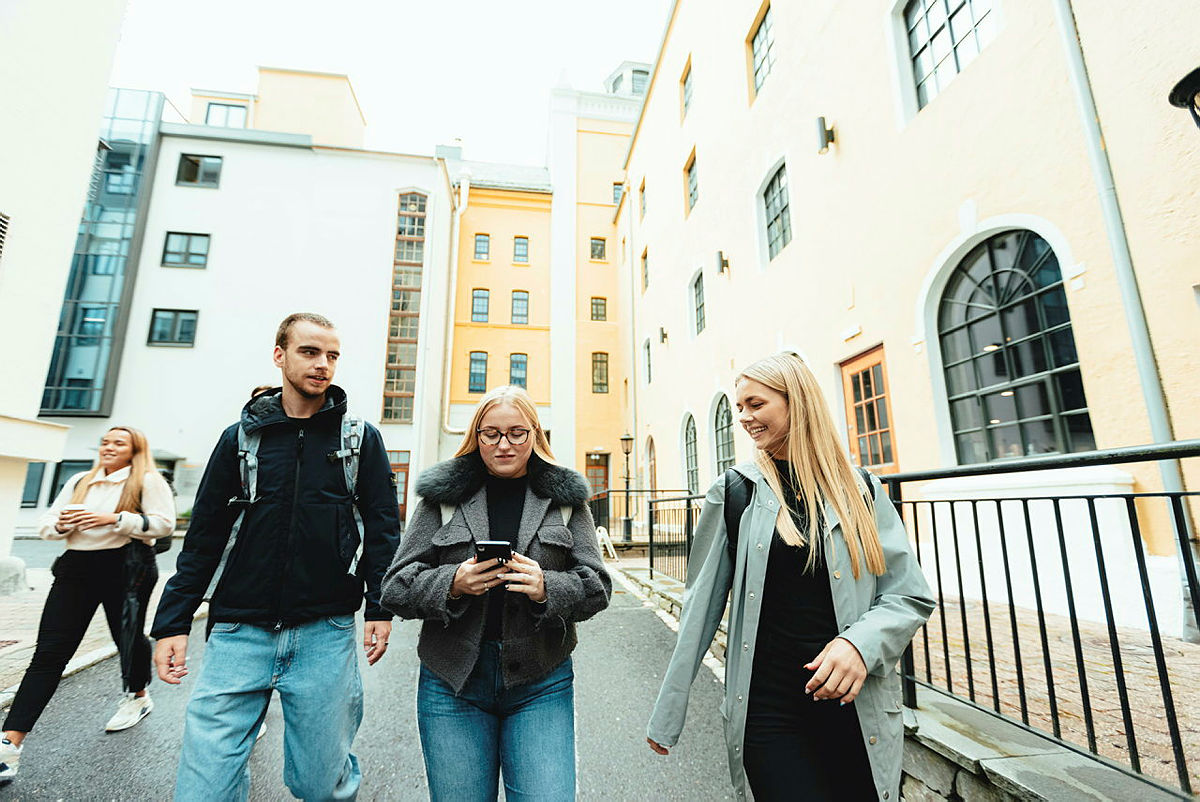Tre studenter avbildet foran Høyskolen Kristiania i Bergen.