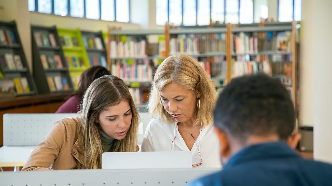 Teacher and student looking at computer