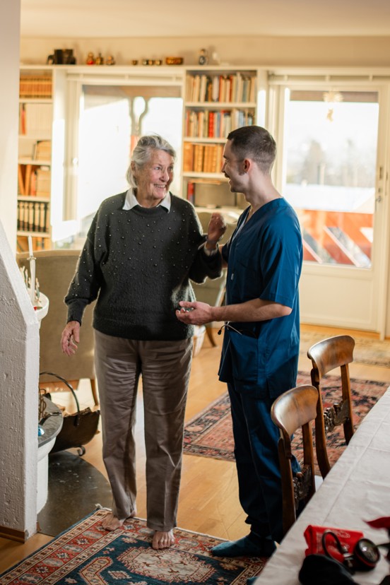 Helsefagarbeider støtter en eldre person i et hjemmemiljø