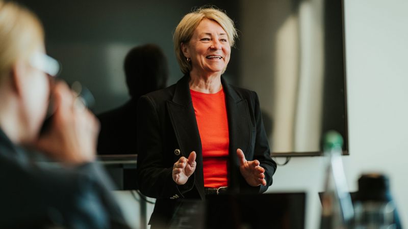 Kvinne holder en presentasjon i et møterom. 