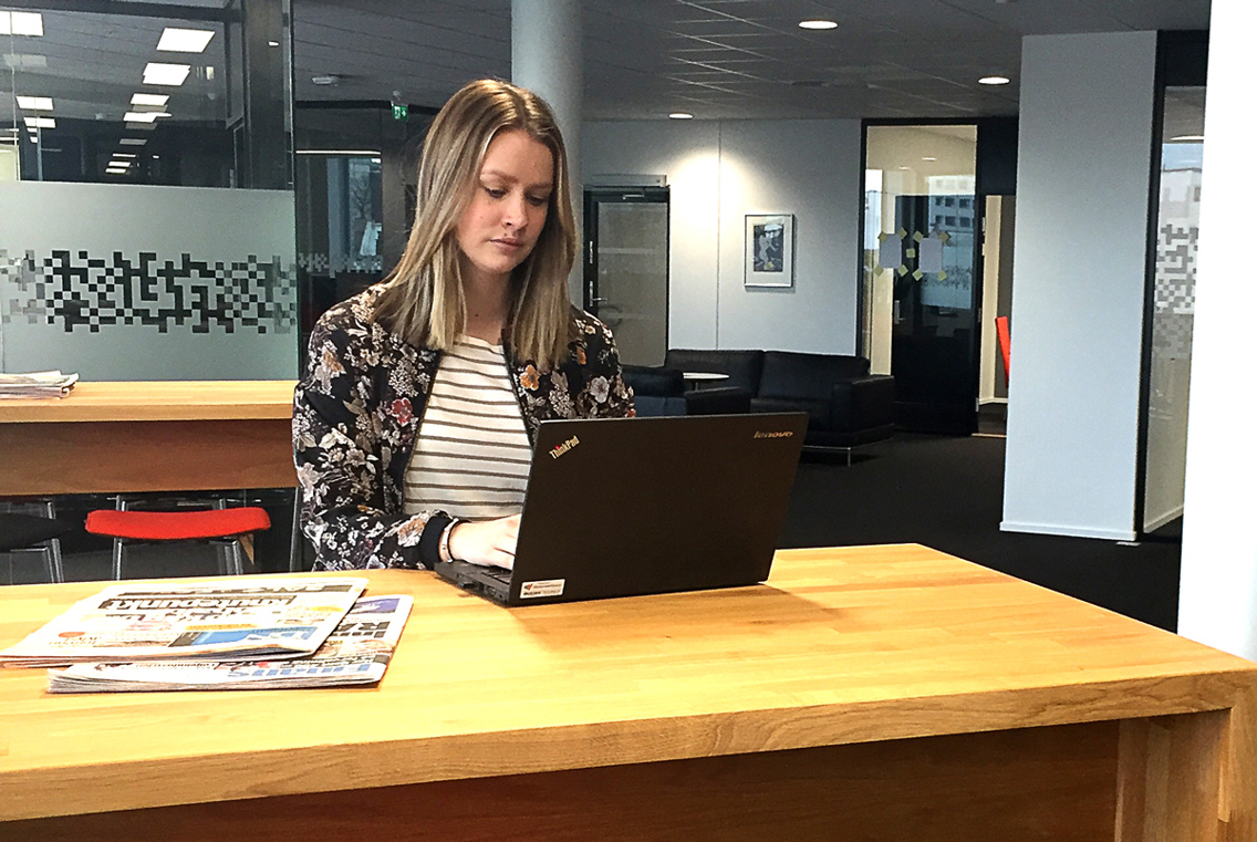 Johanna sitter å skriver i et kontorlandskap.