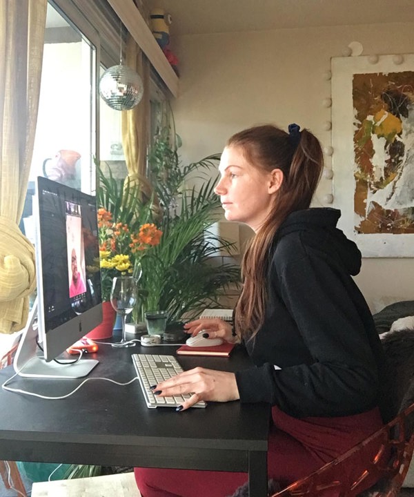 Foto av Julia Spjøtvold som studerer Digital Innholdsproduksjon på Fagskolen Kristiania. Her sitter hun og jobber på hjemmekontoret sitt.