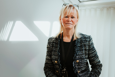 Foto av kvinne i blazer på et kontor.