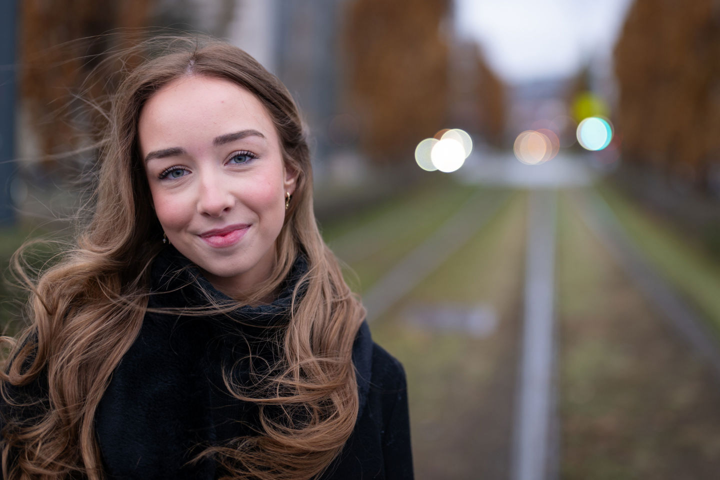 Karine Asperud står foran trikkeskinnene. Hun har langt, mellomblondt hår